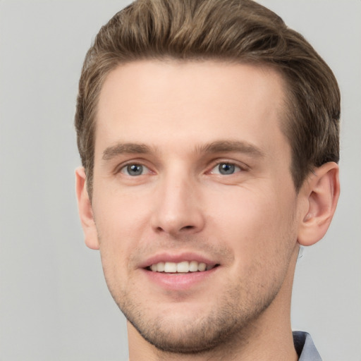 Joyful white young-adult male with short  brown hair and grey eyes