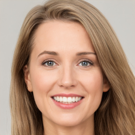 Joyful white young-adult female with long  brown hair and green eyes