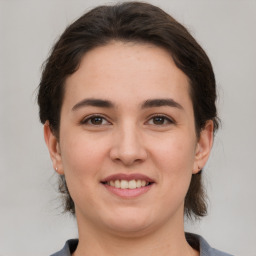 Joyful white young-adult female with short  brown hair and grey eyes