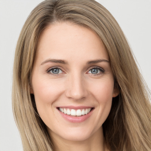 Joyful white young-adult female with long  brown hair and green eyes