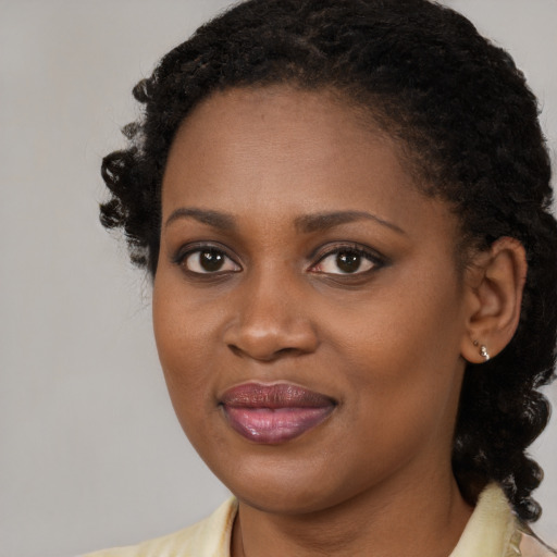 Joyful black young-adult female with medium  brown hair and brown eyes