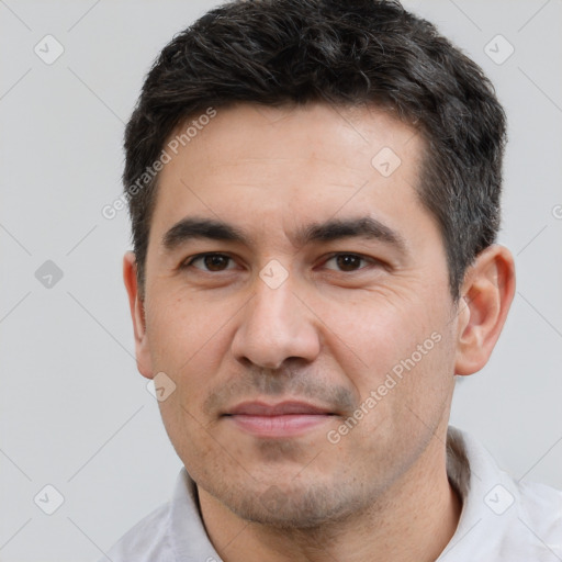 Joyful white adult male with short  black hair and brown eyes