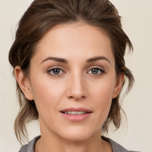 Joyful white young-adult female with medium  brown hair and grey eyes