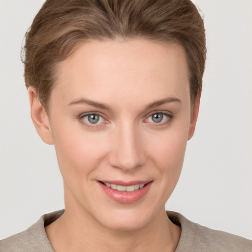 Joyful white young-adult female with short  brown hair and grey eyes