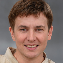 Joyful white young-adult male with short  brown hair and grey eyes