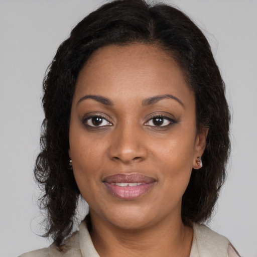 Joyful black young-adult female with long  brown hair and brown eyes