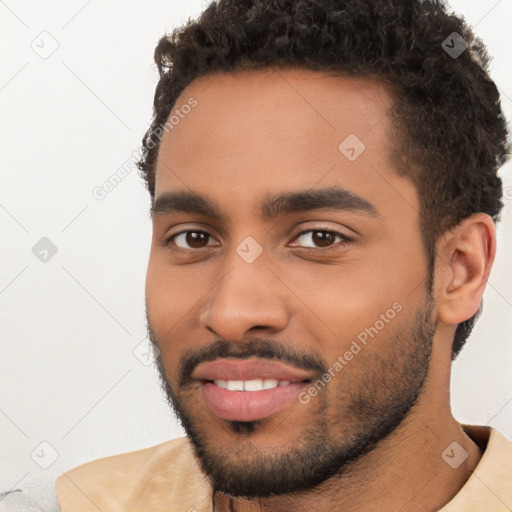 Joyful latino young-adult male with short  brown hair and brown eyes