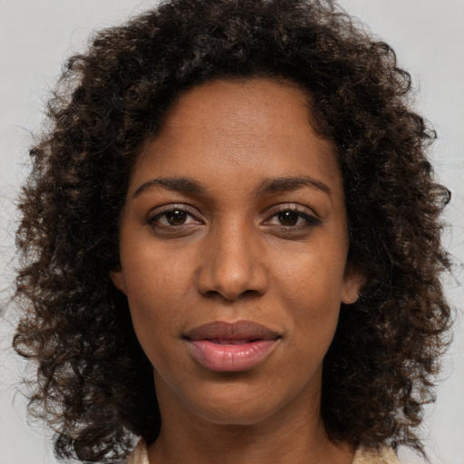 Joyful black young-adult female with medium  brown hair and brown eyes