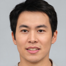 Joyful asian young-adult male with short  brown hair and brown eyes