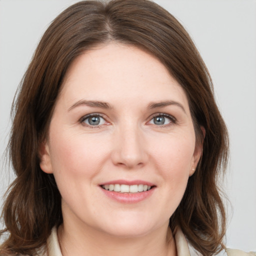 Joyful white young-adult female with medium  brown hair and grey eyes