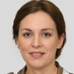 Joyful white adult female with medium  brown hair and grey eyes