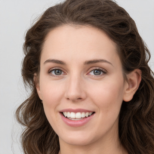 Joyful white young-adult female with long  brown hair and green eyes