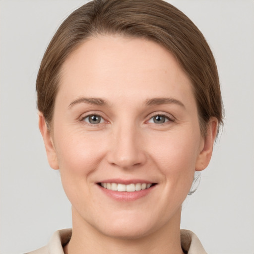 Joyful white young-adult female with short  brown hair and grey eyes