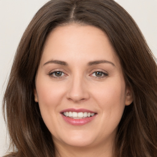 Joyful white young-adult female with long  brown hair and brown eyes