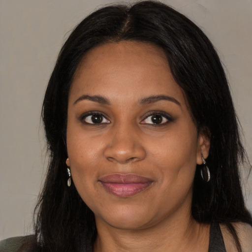 Joyful black young-adult female with long  black hair and brown eyes