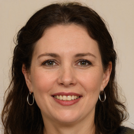 Joyful white adult female with long  brown hair and green eyes