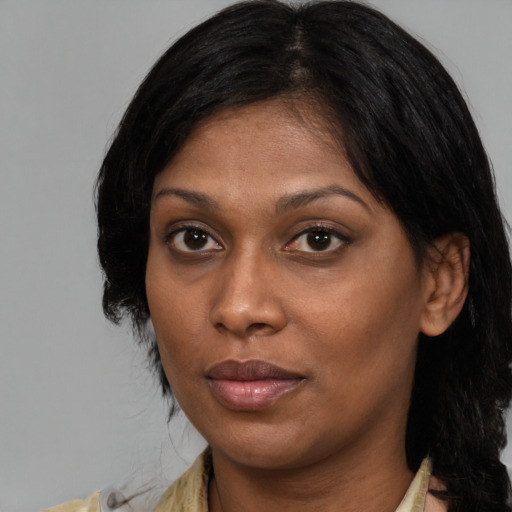Joyful black young-adult female with medium  brown hair and brown eyes