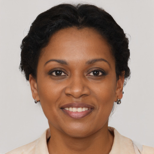 Joyful black adult female with short  brown hair and brown eyes