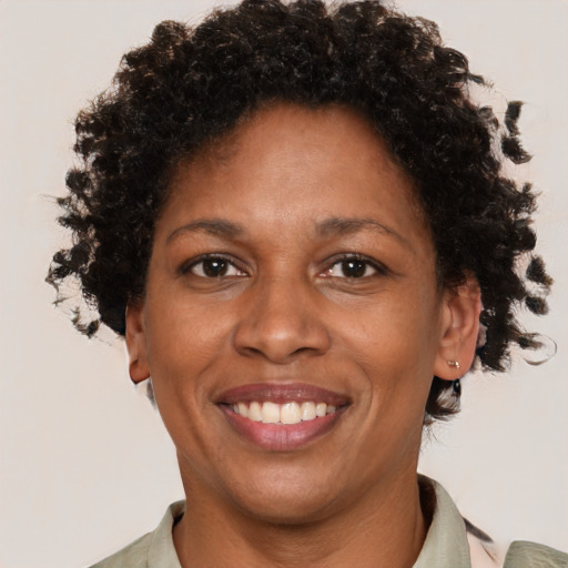 Joyful black adult female with short  brown hair and brown eyes