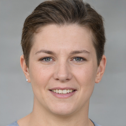 Joyful white young-adult female with short  brown hair and grey eyes