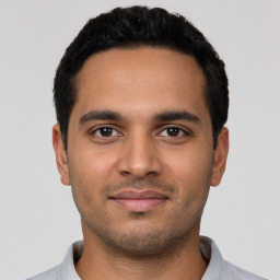 Joyful latino young-adult male with short  black hair and brown eyes