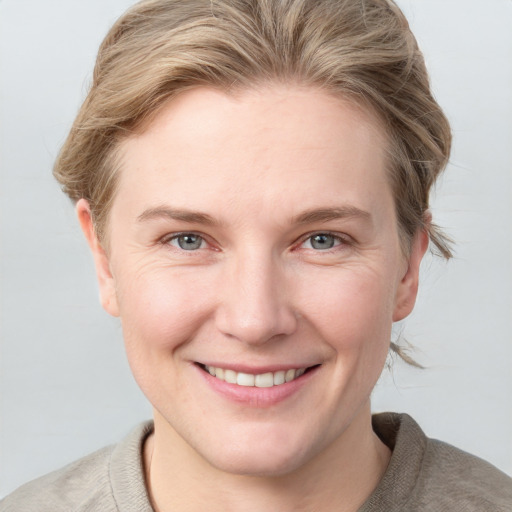 Joyful white young-adult female with short  brown hair and blue eyes