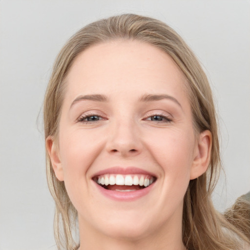 Joyful white young-adult female with long  brown hair and blue eyes