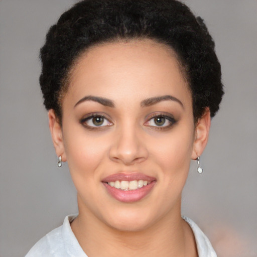 Joyful black young-adult female with short  black hair and brown eyes
