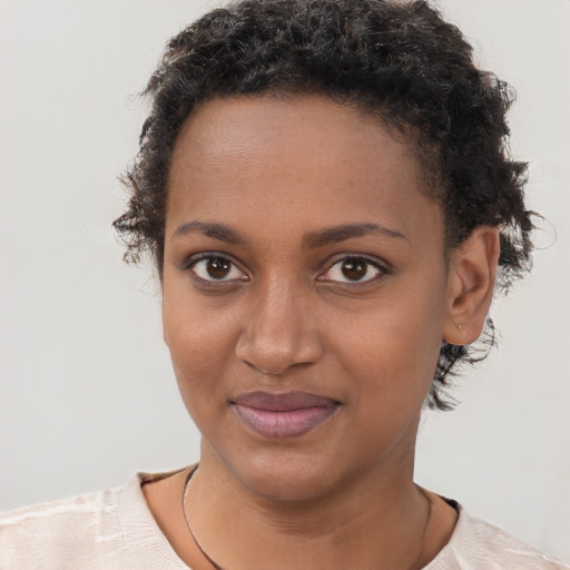 Joyful black young-adult female with short  brown hair and brown eyes