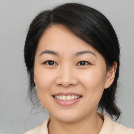 Joyful asian young-adult female with medium  brown hair and brown eyes