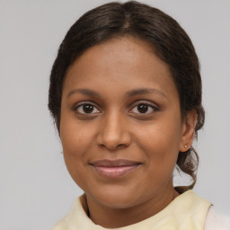 Joyful black young-adult female with medium  brown hair and brown eyes