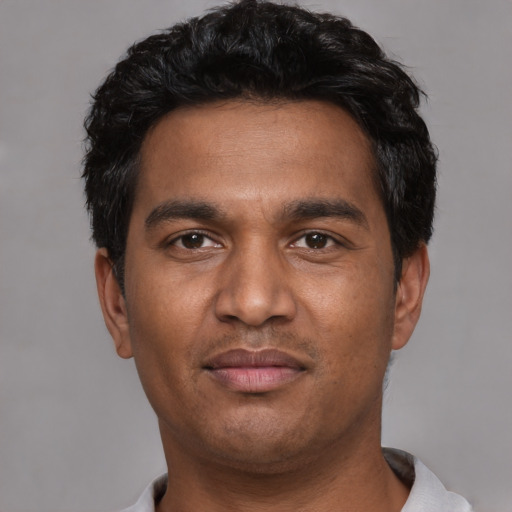 Joyful white young-adult male with short  black hair and brown eyes