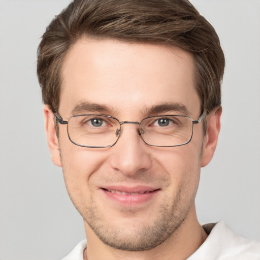 Joyful white young-adult male with short  brown hair and grey eyes