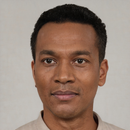 Joyful black young-adult male with short  black hair and brown eyes