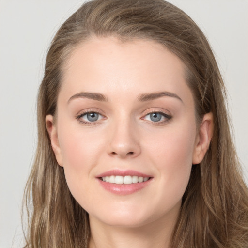 Joyful white young-adult female with long  brown hair and grey eyes