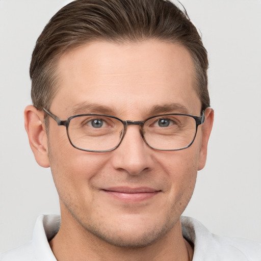 Joyful white adult male with short  brown hair and grey eyes