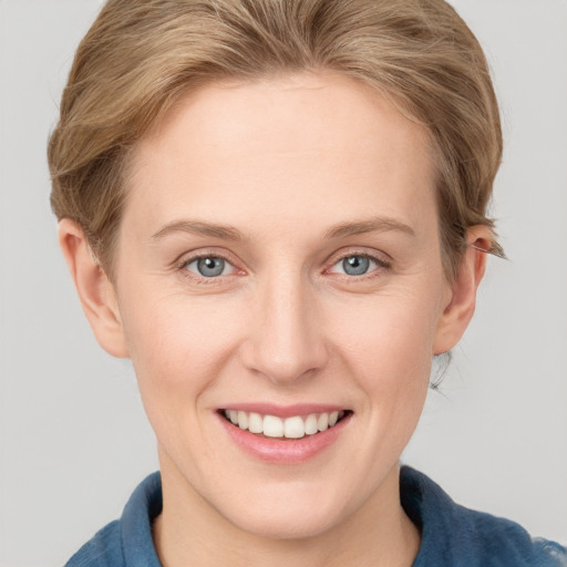 Joyful white young-adult female with short  brown hair and blue eyes