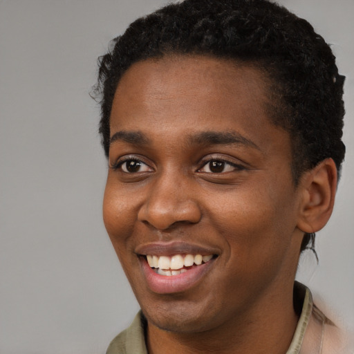 Joyful black young-adult male with short  brown hair and brown eyes