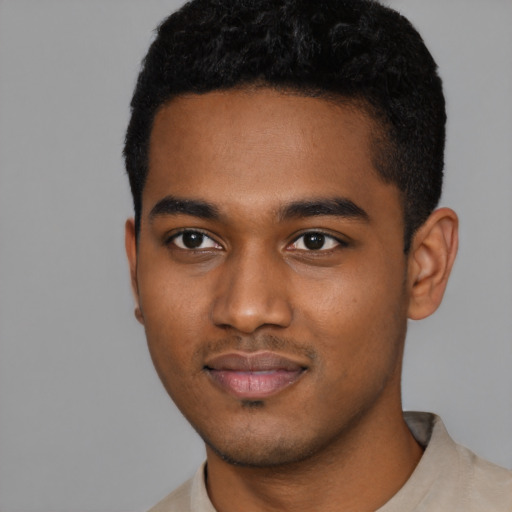 Joyful black young-adult male with short  black hair and brown eyes