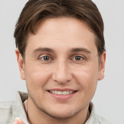 Joyful white young-adult male with short  brown hair and grey eyes