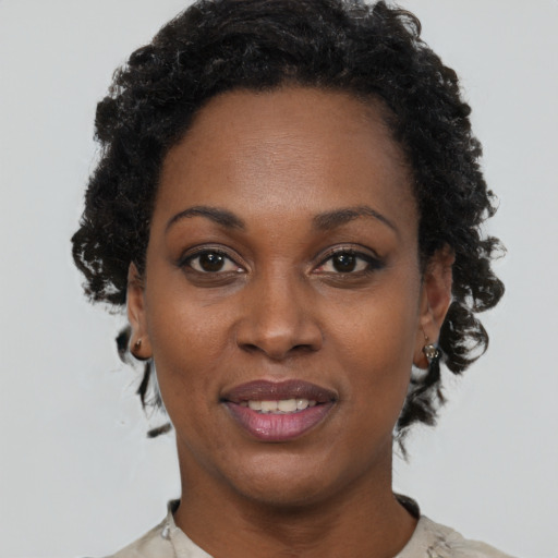 Joyful black young-adult female with short  black hair and brown eyes