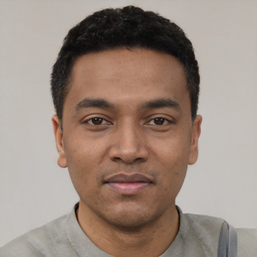 Joyful latino young-adult male with short  black hair and brown eyes