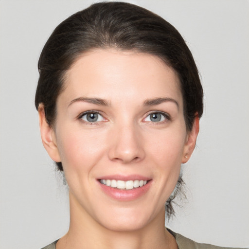 Joyful white young-adult female with medium  brown hair and grey eyes