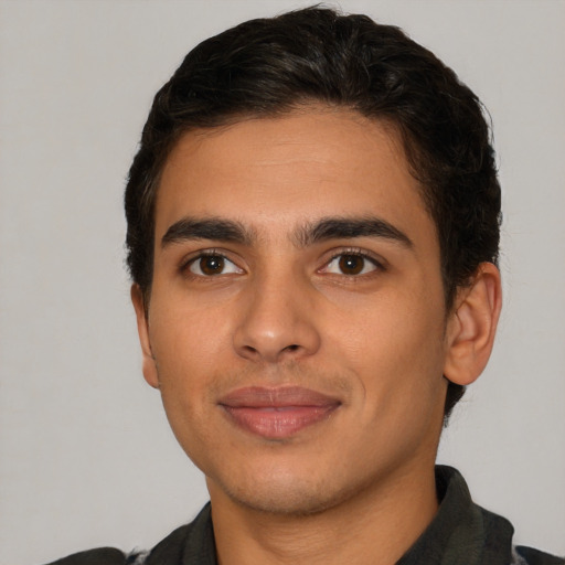 Joyful latino young-adult male with short  brown hair and brown eyes