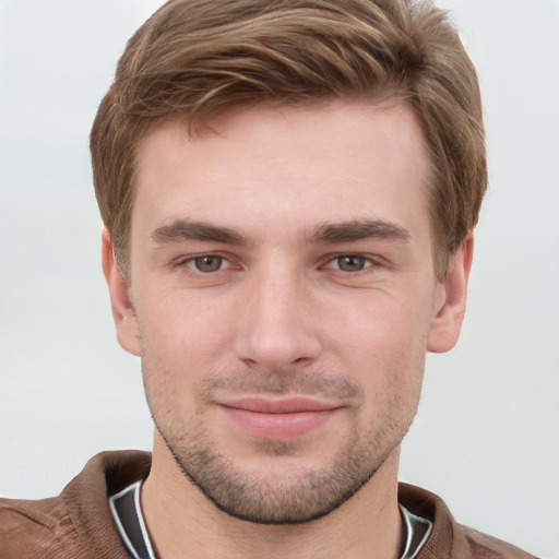 Joyful white young-adult male with short  brown hair and grey eyes