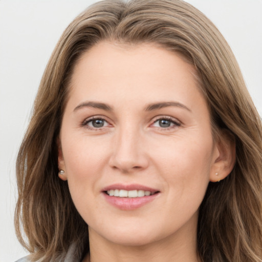 Joyful white young-adult female with long  brown hair and grey eyes