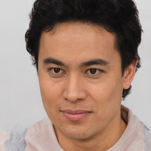 Joyful latino young-adult male with short  brown hair and brown eyes