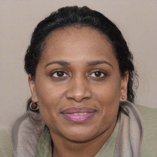Joyful black adult female with medium  brown hair and brown eyes