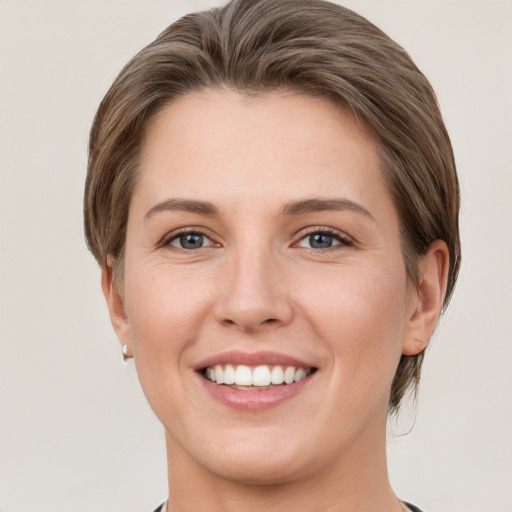 Joyful white young-adult female with short  brown hair and grey eyes