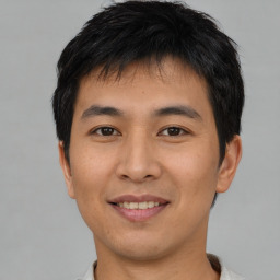 Joyful asian young-adult male with short  black hair and brown eyes